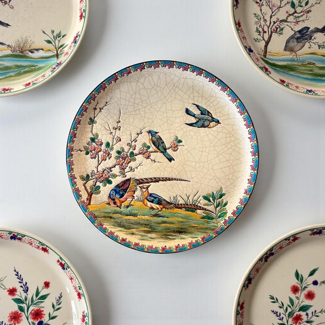 Elegant French faience decorative plate by Émaux de Longwy, featuring a finely detailed bird and flowering branch motif...