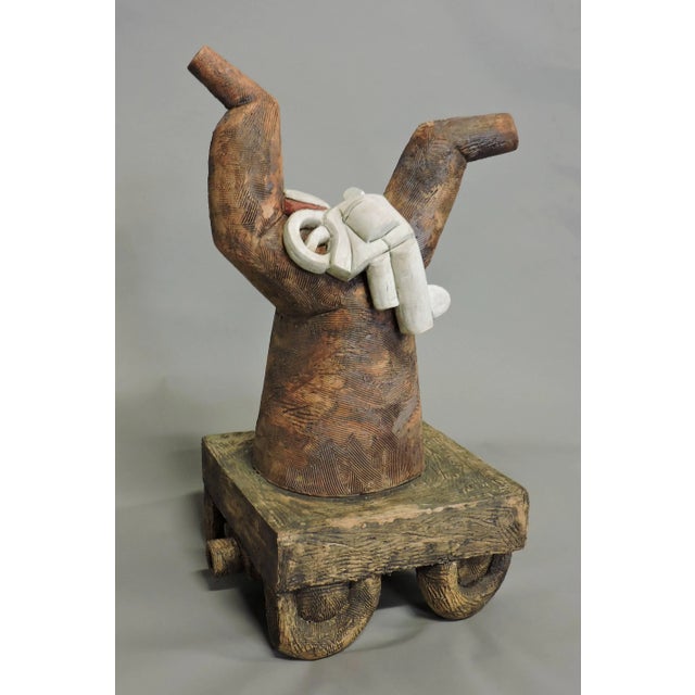 Whimsical wheeled ceramic and plaster sculptures by artist Scott Rosenthal. The larger sculpture is fired ceramic, and the...