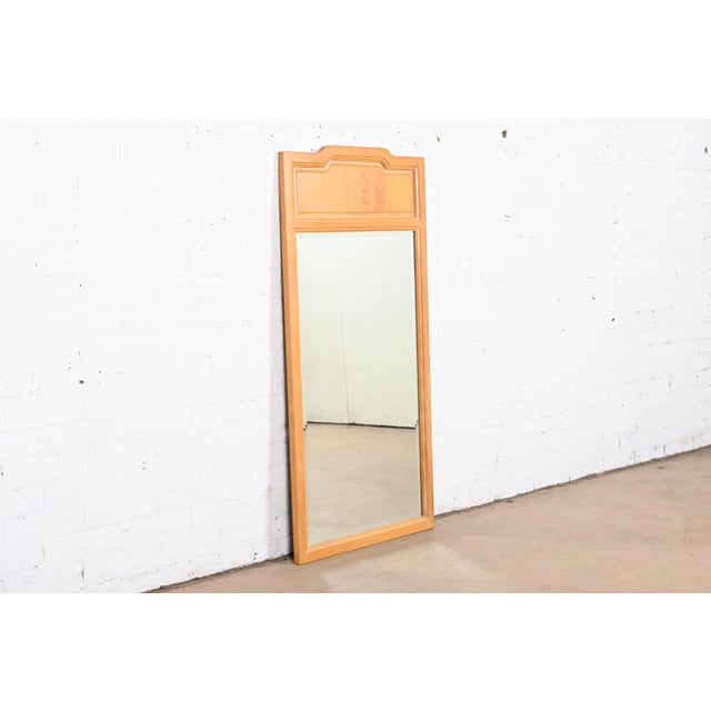 A stylish Mid-Century Modern sculpted ash wood framed beveled wall mirror By Henredon USA, Circa 1970s Measures: 22"W x...