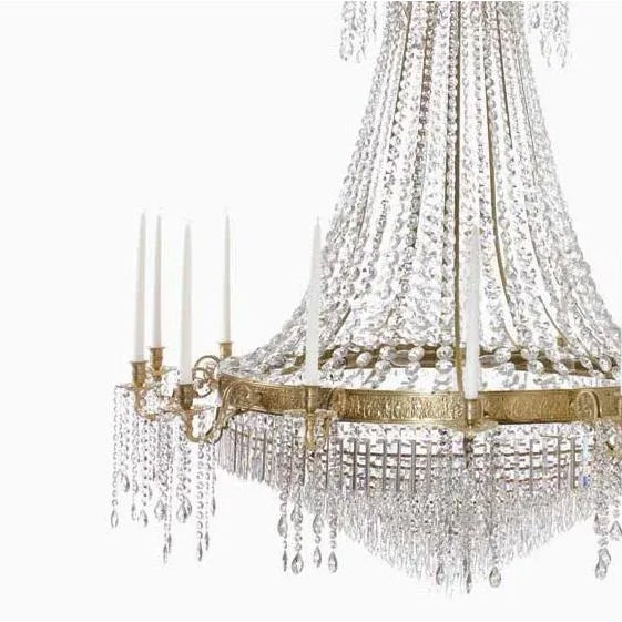 A stylish Empire chandelier in genuine brass, with fourteen sturdy candle holders and an elaborately decorated ring. The...