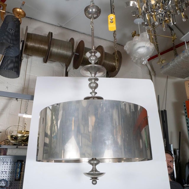 Large scale drum chandelier with mesh diffuser and spun details.