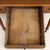 An antique walnut writing desk with a richly grained rectangular top and three drawers across the front. A broad center...
