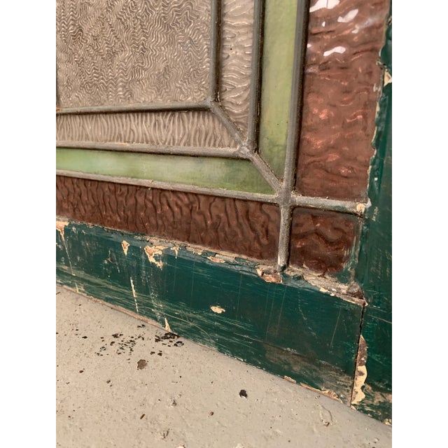 Rectangular framed vintage stained glass featuring bi-color frame. Dimensions: W 24.5" x D 1.5" x H 33.75" Condition: age...