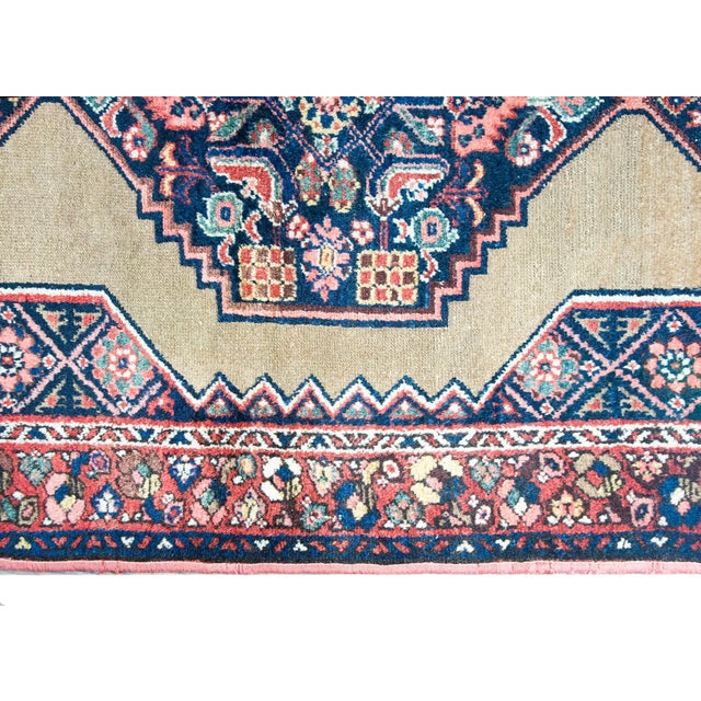 A wonderful early 20th century Persian Malayer rug with a central floral medallion living on a solid tan field, surrounded...