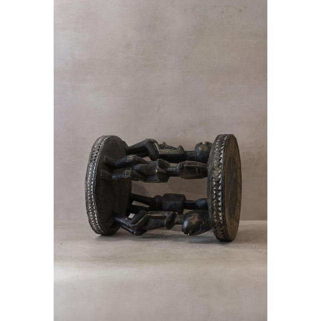 This Baule wood carved vintage stool is a stunning piece of traditional African craftsmanship. Hand-carved from solid wood...