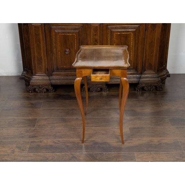 A French Louis XV style walnut side table from the 19th century, with tray top, single drawer and cabriole legs. Created...