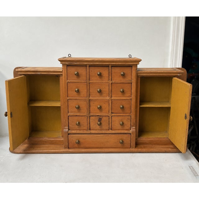 This is a charming antique primitive continental wall mounted pine apothecary or spice shelf. It is purported to be from...