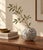 A small art glass vase with a rounded silhouette and striking black-and-white decoration. Fine speckling creates a richly...