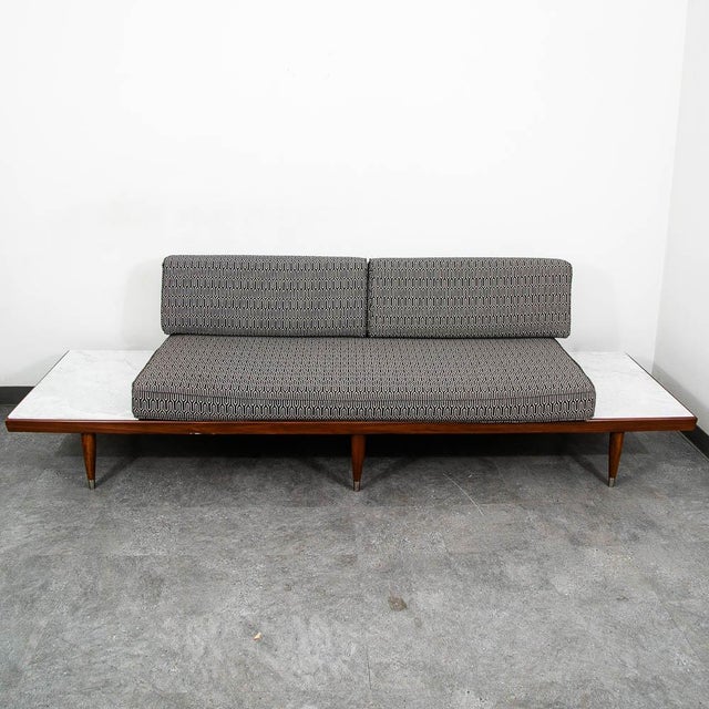 Stunning walnut daybed/sofa with built-in travertine side tables. Designed by Adrian Pearsall for Craft Associates. This...