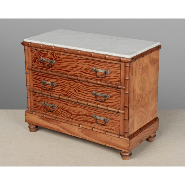 A French faux bamboo miniature marble top commode made of pine and cherry woods. Three drawers with brass pulls. Nicely...