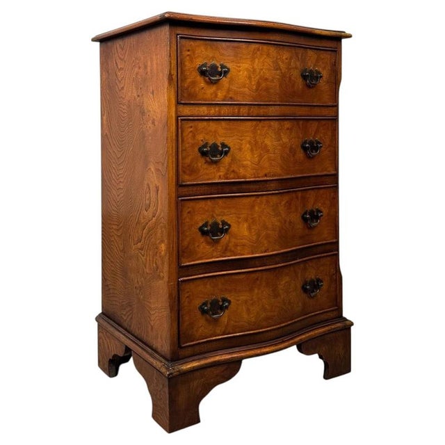 A beautifully shaped and highly desirable 20th-century small serpentine chest of drawers in burr oak, combining...