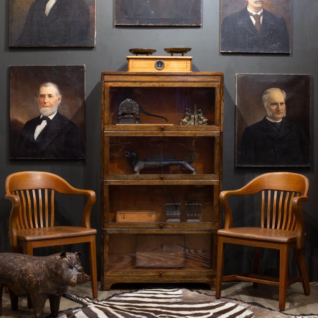 ABOUT An antique lawyer's bookcase with four modular, stacking glass-front tiers plus top crown molding and a footed base....