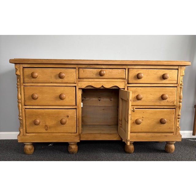 This 19th century English pine sideboard exudes rustic charm and timeless elegance, showcasing craftsmanship and...