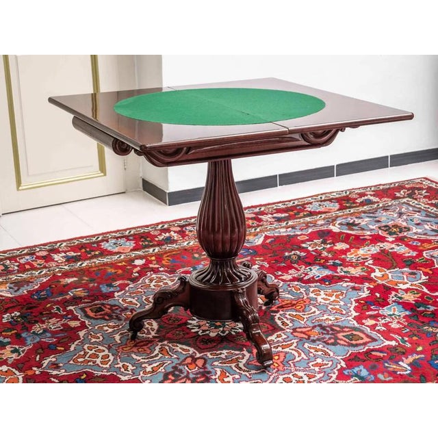 Hand-carved 19th century game table on a central leg divided by a tripod. Fine floral carving. Inside the table is a...
