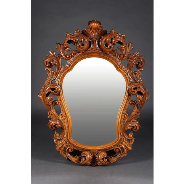 Monumental mirror in Rococo style Walnut, finely carved. Highly shaped mirror-shaped mirror frame. Rich acanthus and rock...