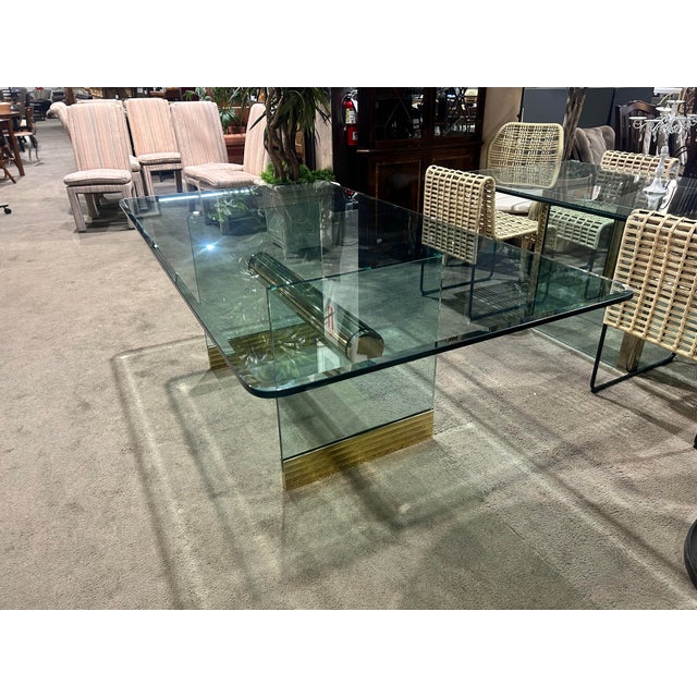 Elevate your dining space with this striking Postmodern glass dining table, featuring a sleek tempered glass top and an...