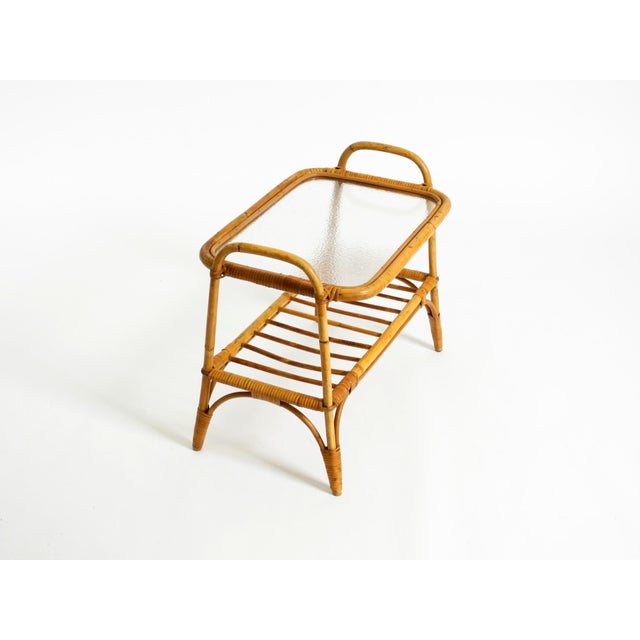 A beautiful, small, original Italian bamboo side table from the 1960s, featuring a lower shelf. The top retains its...