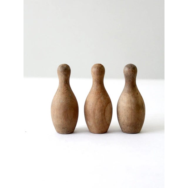Add a touch of vintage charm to your space with this set of three tabletop bowling pins. These handcrafted wooden...
