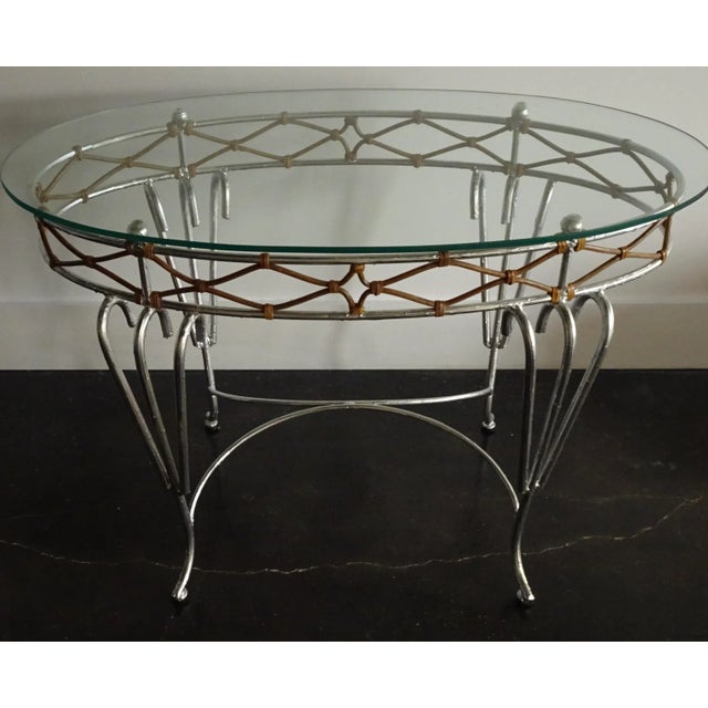 Rococo console possibly 1950s. Oval form, silvered textured metal frame with decorative cane woven into the top trim and...