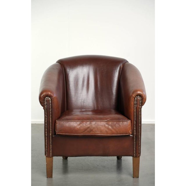 Sheepskin club armchair in a dark cognac color in the English style. : This sheepskin club armchair is made in the English...