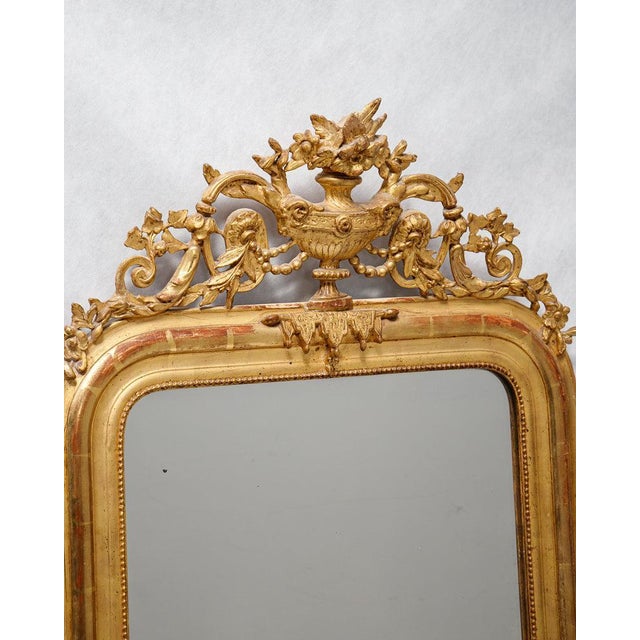 Antique French Gold Gilt Mirror with a Vase and Flower Crest, Circa 1880. This gorgeous antique mirror dates back to...