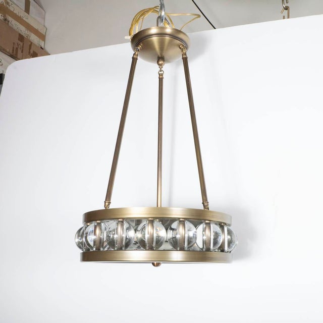 Tambour pendant in antique brass finish with glass ball details by David Duncan.