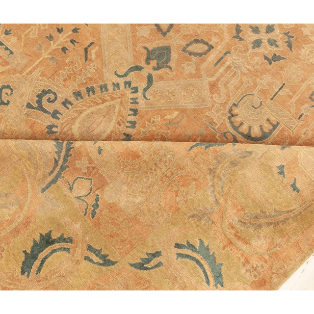 An early 20th century Indian antique rug, the abrashed light brown field with an overall symmetrical design of abstract...