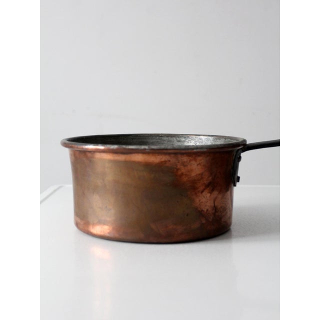 This antique copper saucepan dates to the late 19th to early 20th century and features a hand-worked copper body with a...