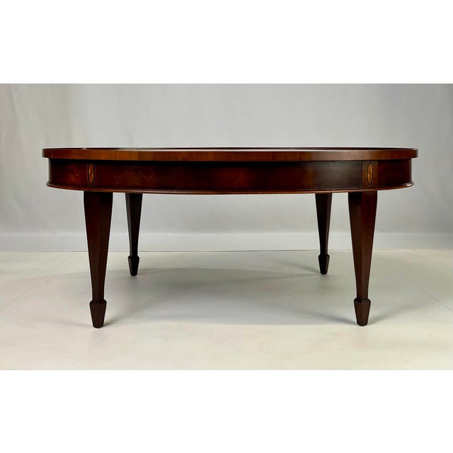 Beautiful oval coffee table by Hekman Furniture, crafted in Grand Rapids, Michigan. This piece features a striking crotch...