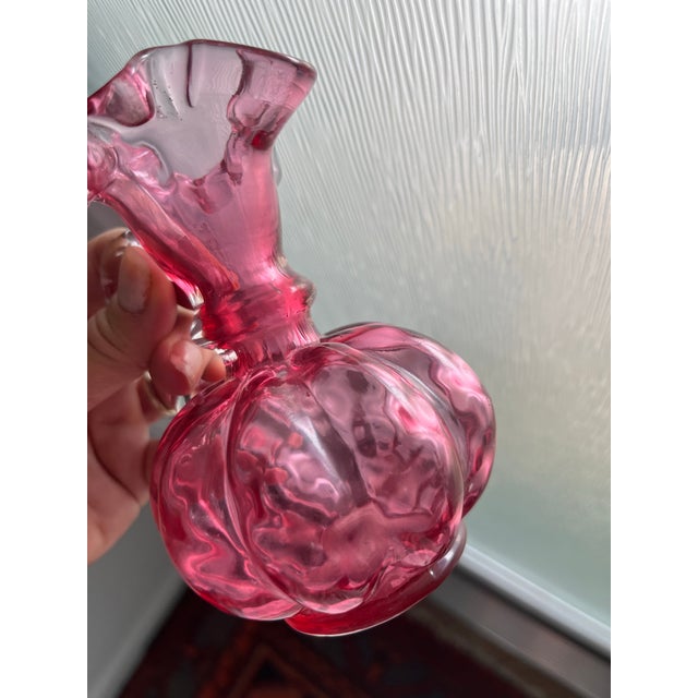 Antique cranberry (ruby) glass pitcher with ruffled rim and applied clear handle. Paneled melon-form body with rich color....