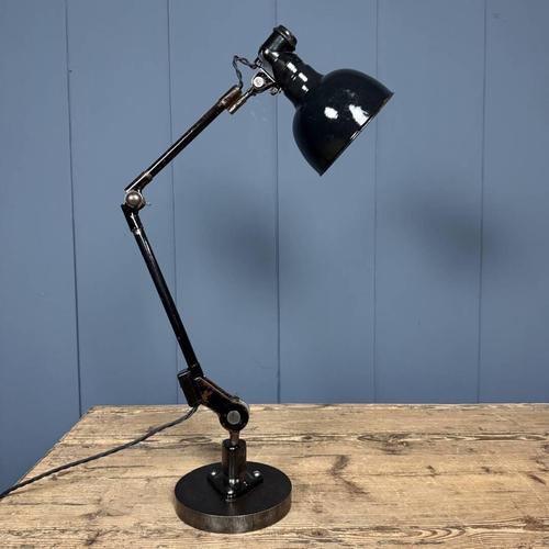 Black Rademacher table lamp on a heavy iron base. This lamp originates from Germany, dating from around 1930. This machine...