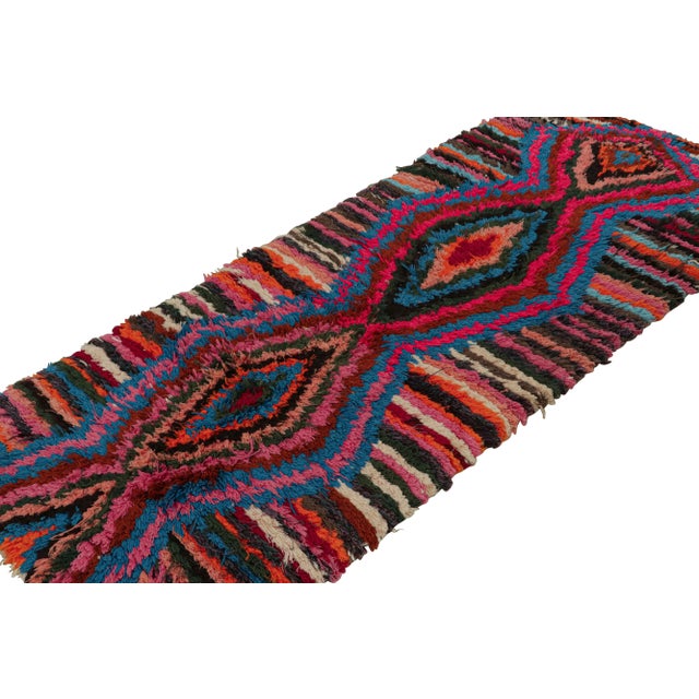 Hand-knotted in wool circa 1950-1960, this 3x6 vintage Moroccan runner rug with polychromatic diamond medallions and...