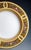 A porcelain plate decorated with the finest painting: border with a lemon-yellow background behind five large, curved gold...