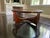 Hickory Chair elegant round coffee table featuring a thick glass top and sculptural wood base with graceful curved...