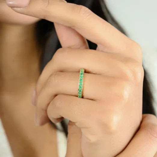 Stackable Sleek Emerald Round Cut Band Ring in 14K Gold featuring natural emerald of 0.52 carats. The gorgeous handcrafted...