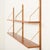 This minimalist danish mid-century teak shelving unit is a modular system with an attractive, airy aesthetic. It is...