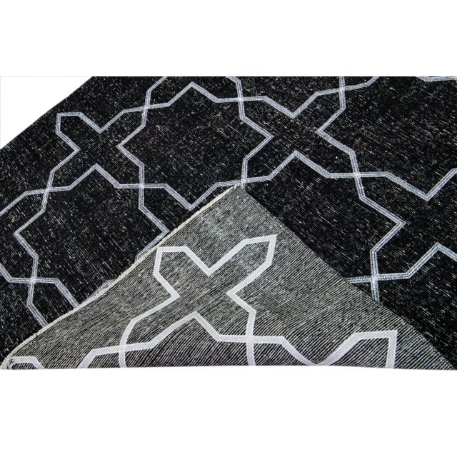 Beautiful Turkish handmade wool rug with a black distress look field. This Modern rug has white accents featuring a...