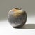 The textured surfaces and perfectly rounded profile give this glazed ceramic vase an almost sculptural presence, where...