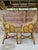 Exceptional pair of vintage French-style rattan bistro side arm chairs featuring beautifully sculpted silhouettes and...