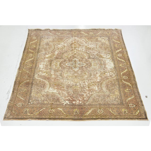 This Persian wool rug features a beige field with green and peach accents in a medallion design throughout. This rug...