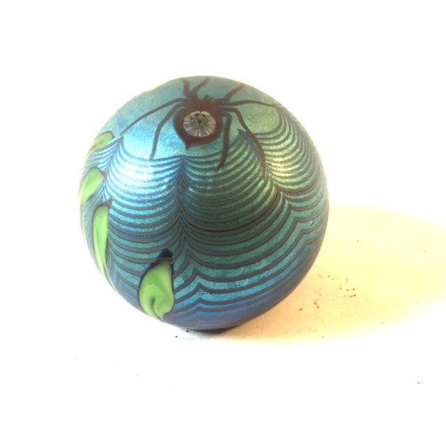 Featuring a spider in its web entangling a flower, this beautiful Art Glass paperweight is signed Orient & Flume 1979. The...