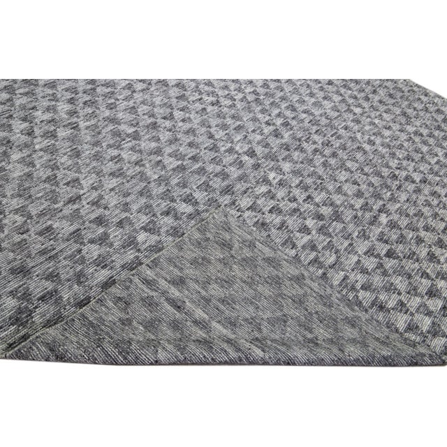 Beautiful modern Apadana's Safi Collection hand-knotted wool rug with a gray field. This Modern rug has gray accents in a...