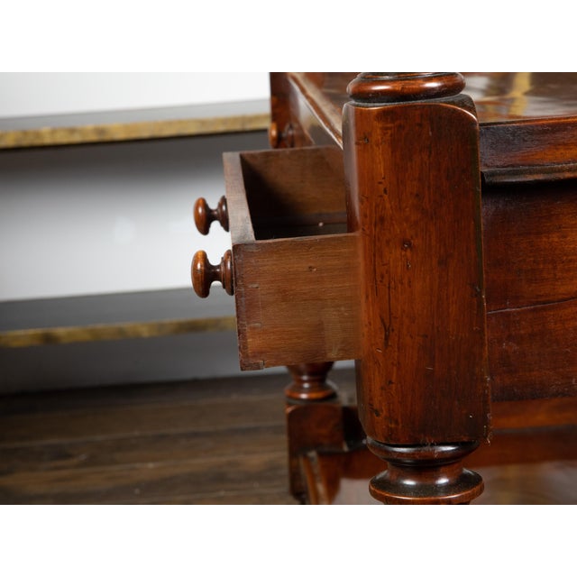 An English mahogany trolley from the early 19th century, with two drawers and brass casters. Created in England during the...