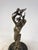 An elegant bronze figurative sculpture depicting a posed female figure surrounded by a flock of birds in flight. A work...