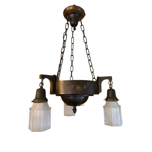 A great early 1900’s chandelier that would look great in any style home. The ribbed shades give a great diffused light....