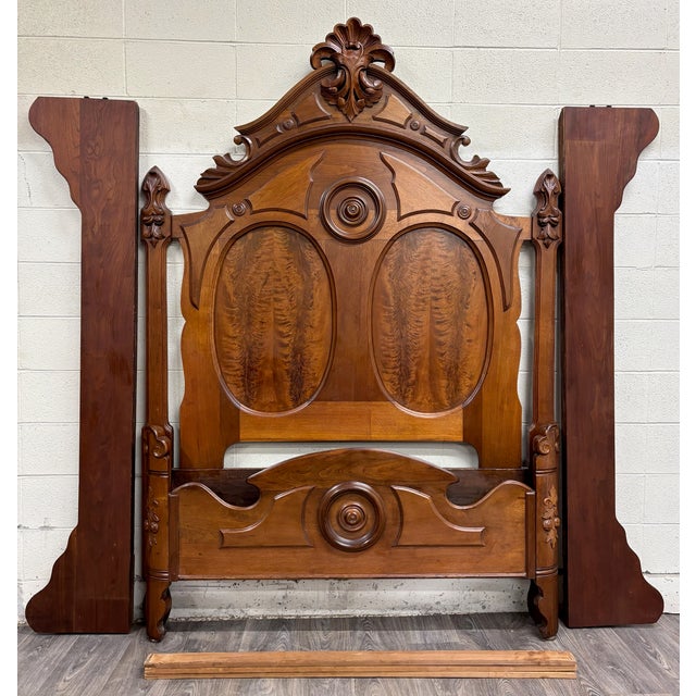 This is a beautifully carved late-Victorian Eastlake style full sized bed crafted in solid walnut with striking flame...