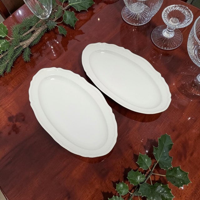 These Limoges scalloped oval serving platters are a matching set of two vintage French porcelain serving pieces, each...