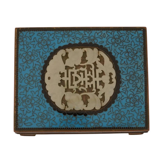 A Japanese cloisonne enamel box. The ware features a vibrant turquoise ground decorated with intricate scrolling wirework....