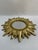 A very bright and stunning gold gilded 12.5" Sunburst Wall Mirror, circa 1990s. This fabulous mirror features a notched...