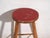 This antique wooden stool is a three-legged seat with a round seat and turned splayed legs joined by stretchers. It...